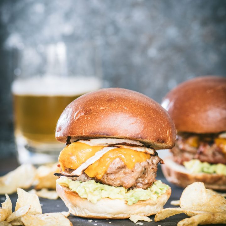 Close up of a southwestern turkey burger slider with potato chips scattered in front
