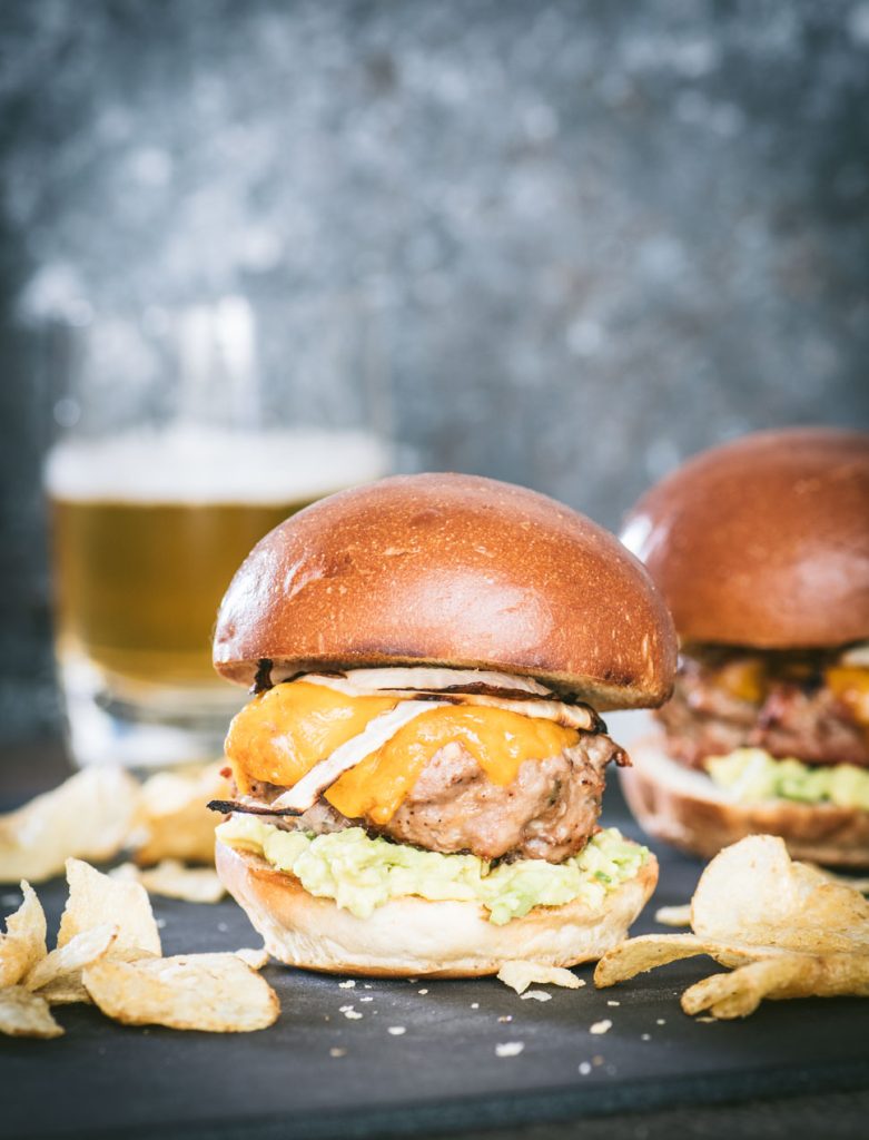 Close up of a southwestern turkey burger slider with potato chips scattered in front