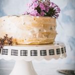 Lemon Lavender layer cake with buttercream frosting topped with purple flowers