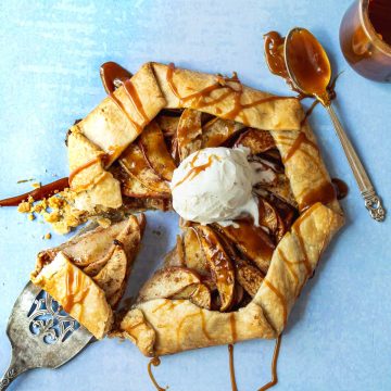 Apple galette topped with vanilla ice cream scoop on a light blue background