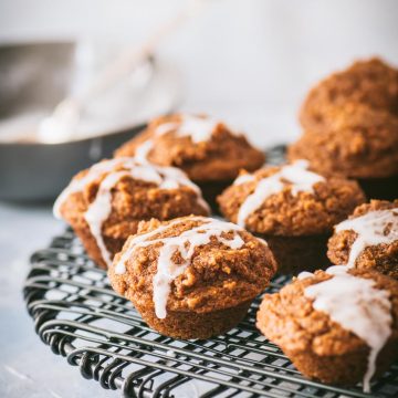 Close up of mini pumpkin muffins on a black wire rack