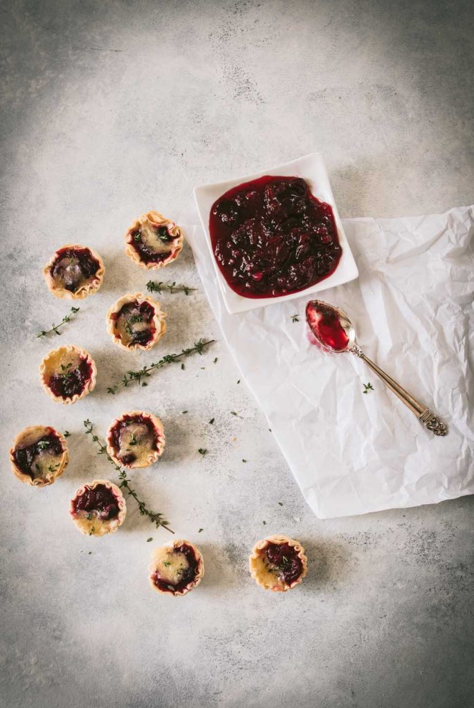 Several mini cranberry brie tarts shot from overhead