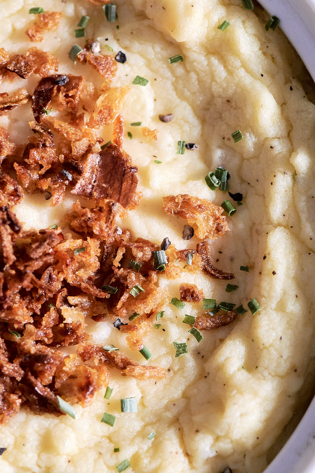 Close up overhead shot of mashed potatoes topped with crispy onions