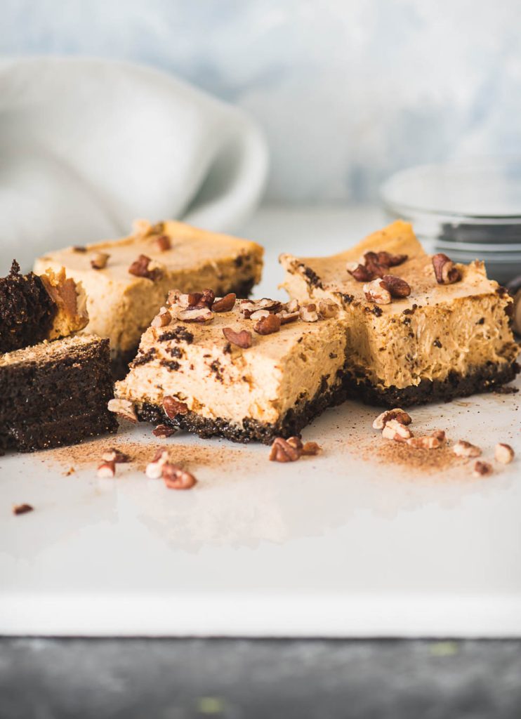 Pumpkin cheesecake bars dusted with ground nutmeg