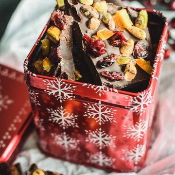 Pieces of chocolate bark in a red holiday gift tin