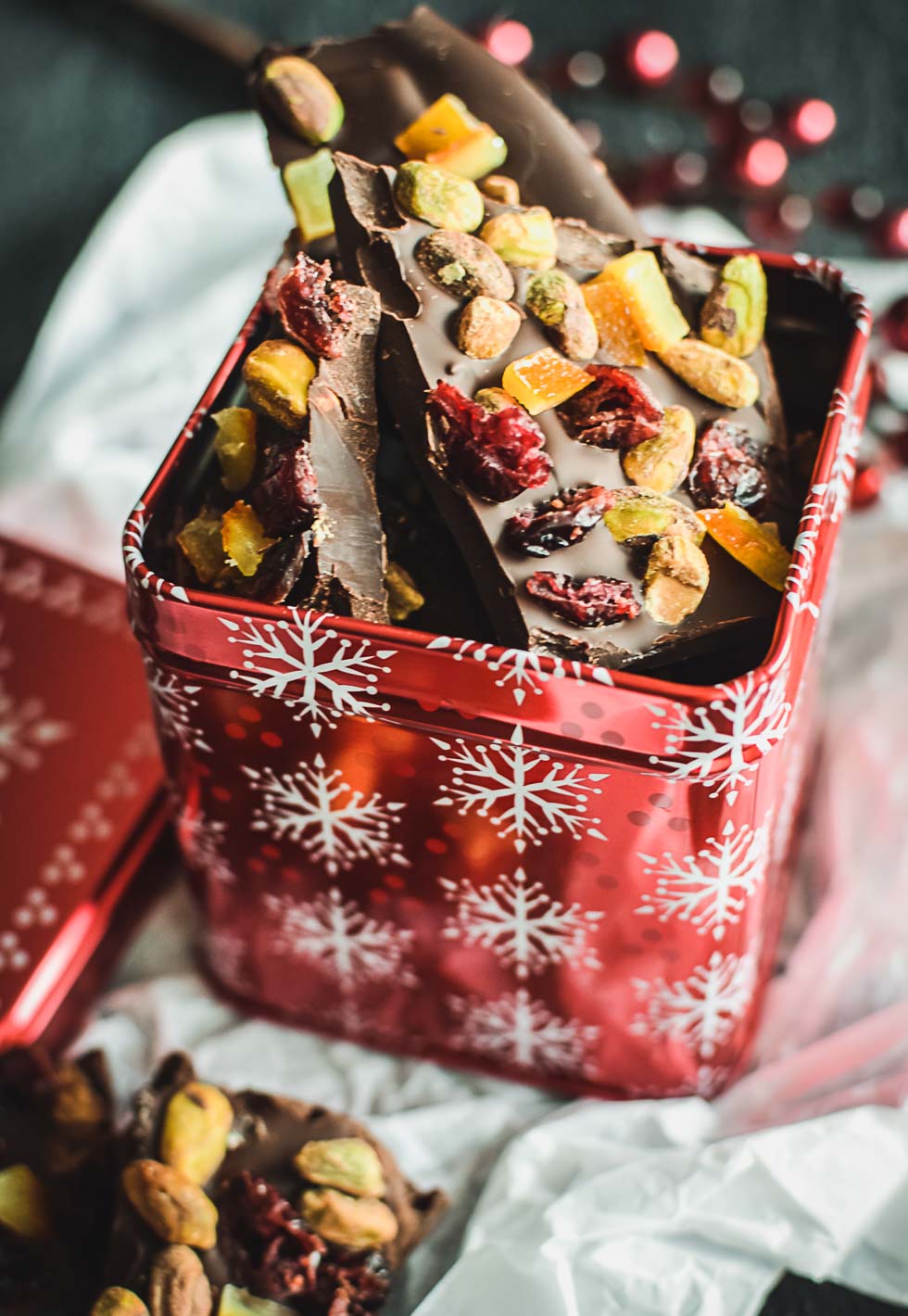 Pieces of chocolate bark in a red holiday gift tin