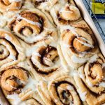 Close up of orange cinnamon rolls drizzled with glaze