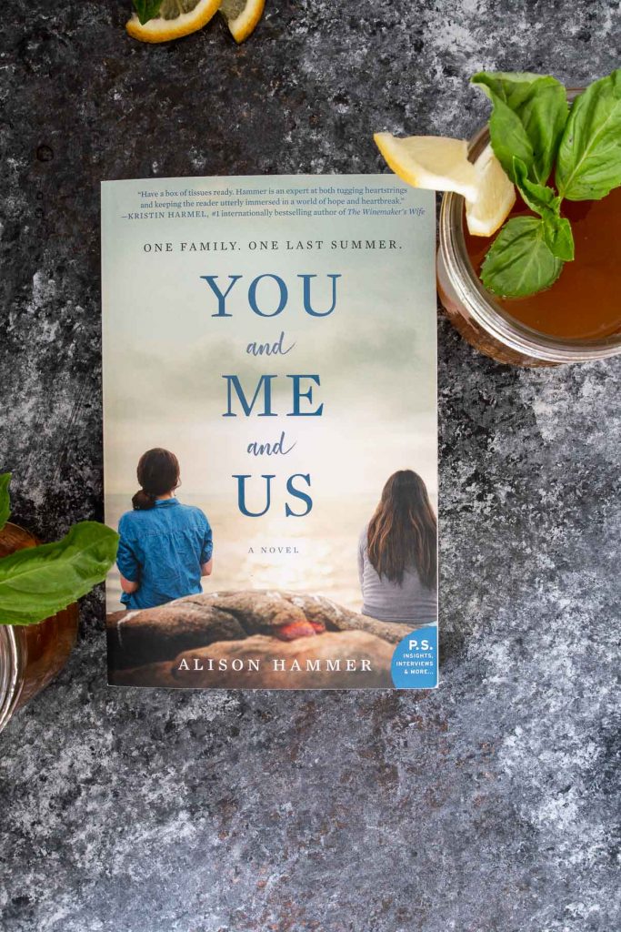 You + Me + Us book with cocktail on the side, shot from overhead
