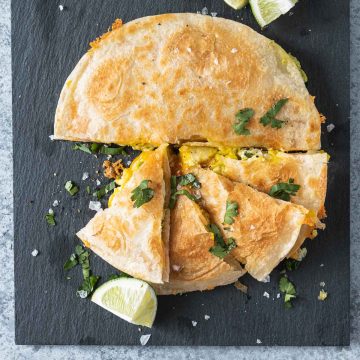 Breakfast quesadilla on a black slate board shot from overhead