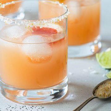 Close up of two grapefruit margaritas in salt rimmed glasss