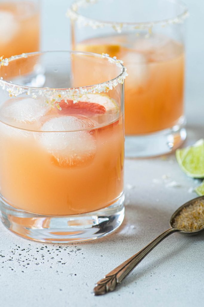 Close up of two grapefruit margaritas in salt rimmed glasss