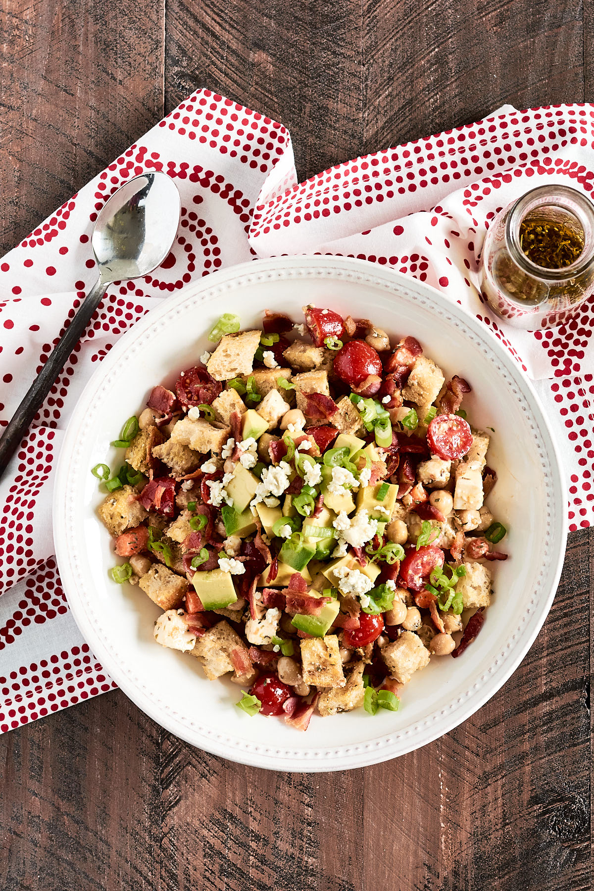 Overhead shot of a salad of bread cubes and veggies in a white bowl