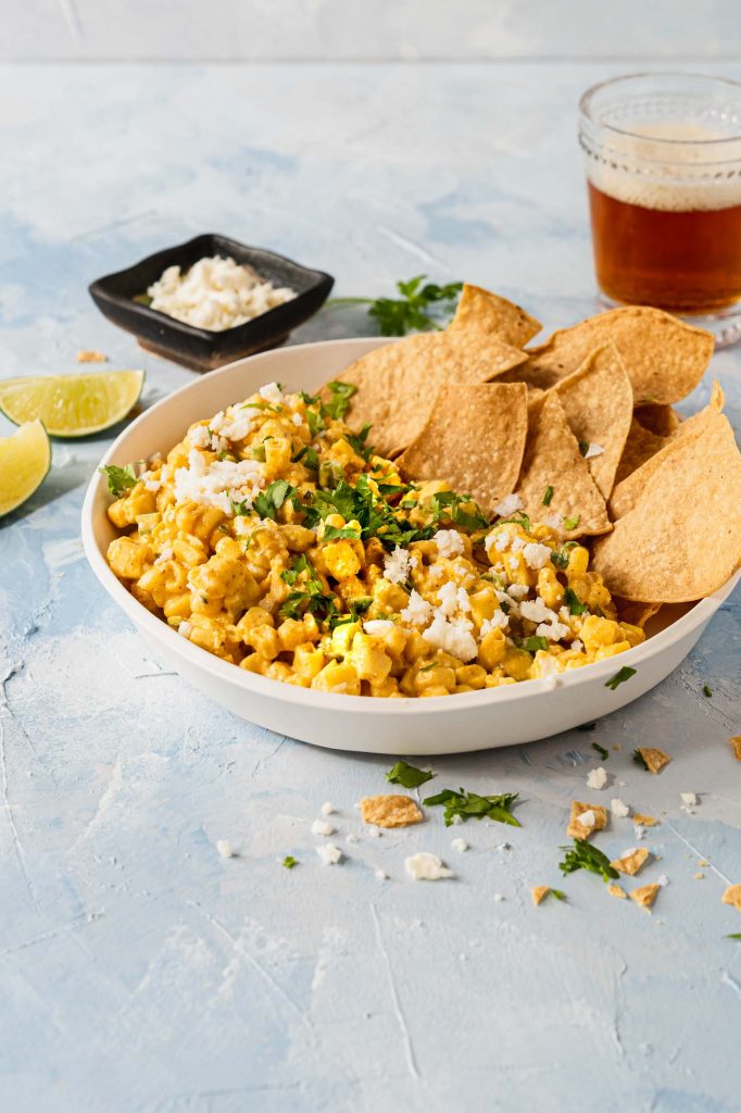 A bowl of Mexican Corn dip topped with queso fresco and cilantro