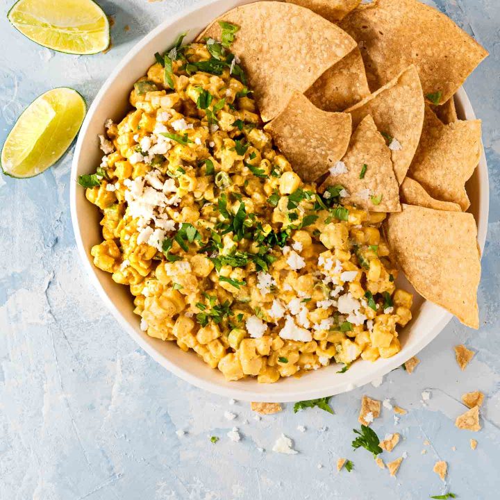 Overhead shot of Mexican Street Corn dip in a white bowl with tortilla chips