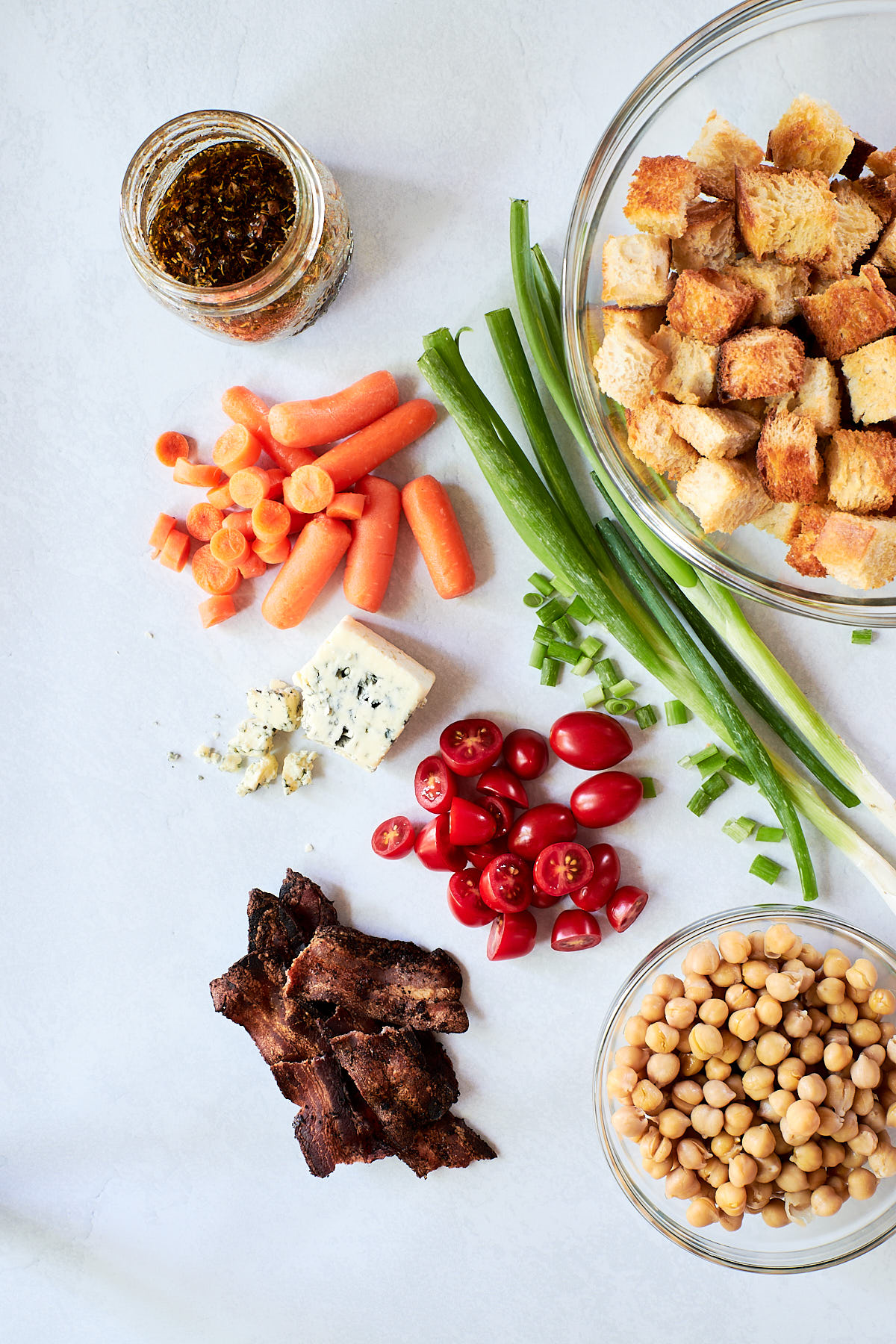Ingredients for panzanella salad - green onions, bacon, tomatoes, chickpeas and bread cubes