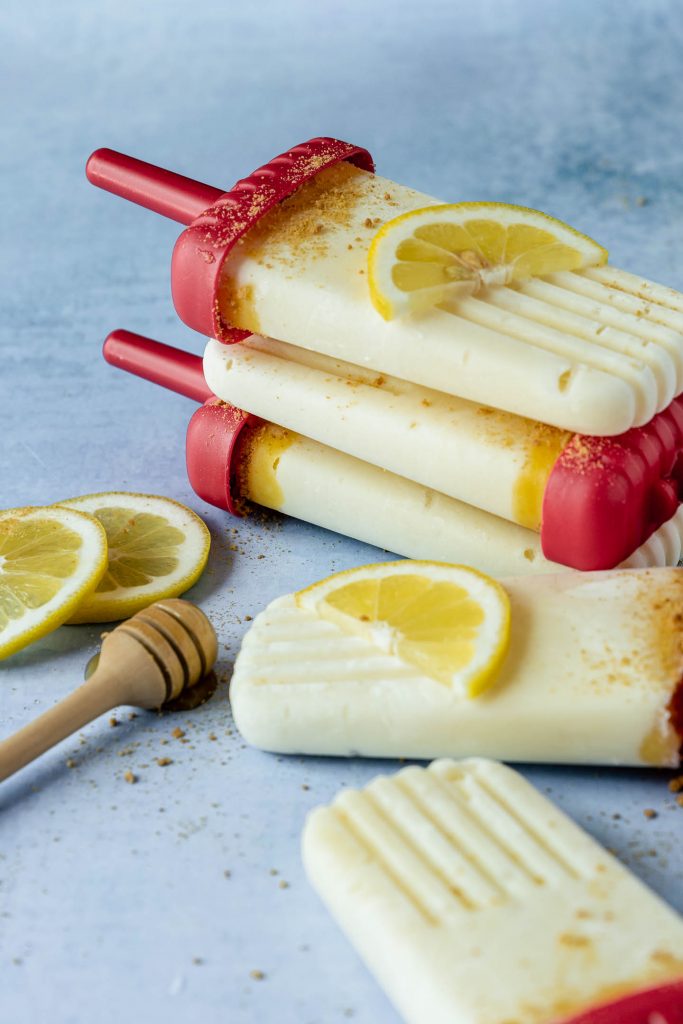 Three creamy lemon popsicles stacked on top of each other. 