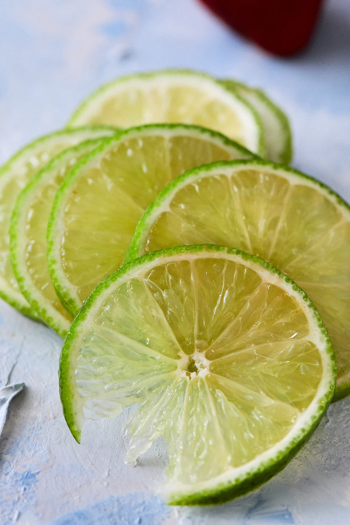 Several lime slices on a light blue background