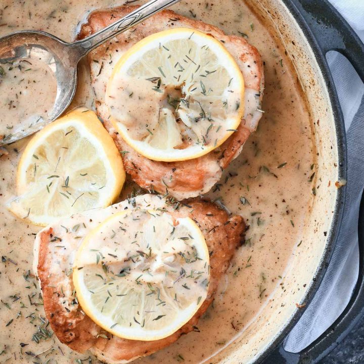 Overhead shot of chicken breasts with lemon sauce in a skillet