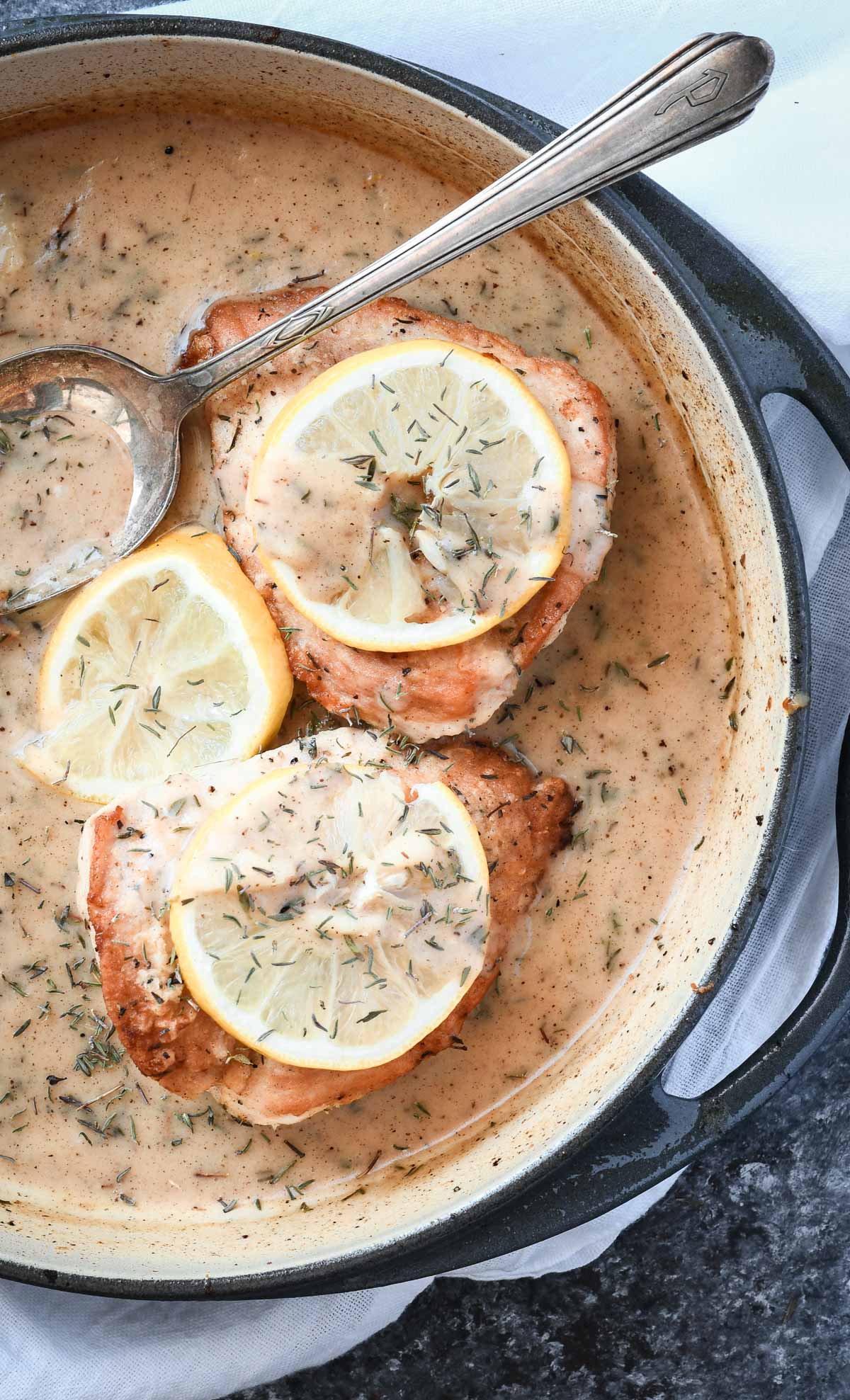 Overhead shot of chicken breasts with lemon sauce in a skillet