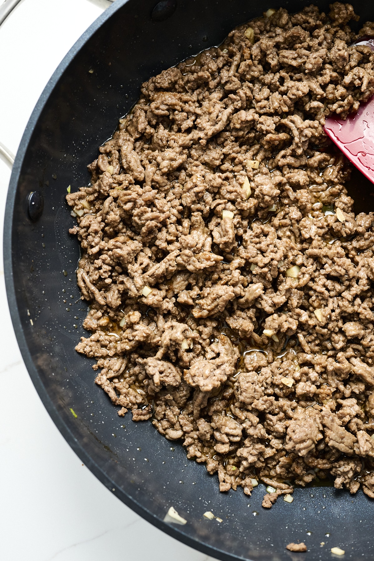 Browned ground beef in a skillet with Korean spices added