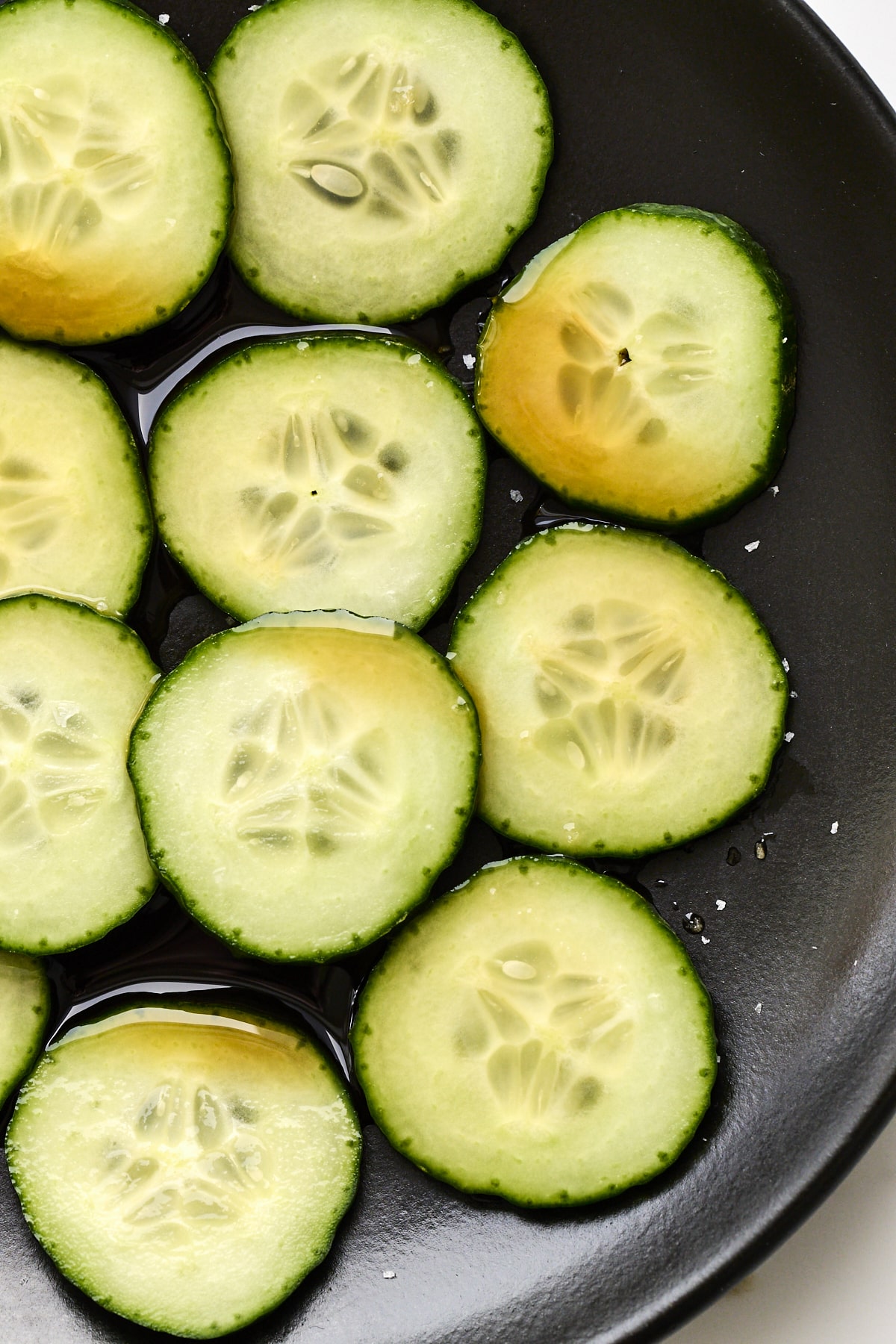 Sliced cucumber on a matte black plate