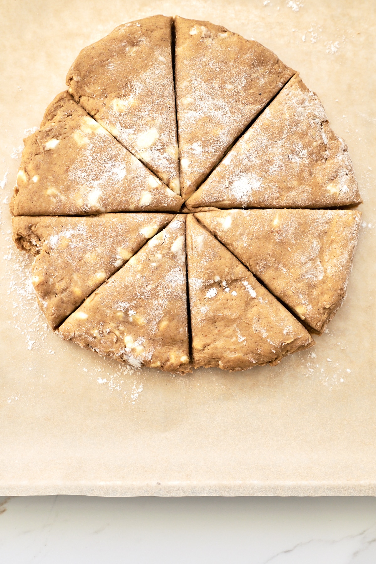 Disc of pumpkin scone dough, sliced into wedges