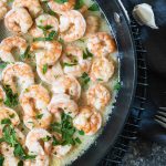 Overhead shot of garlic butter shrimp in a dark skillet
