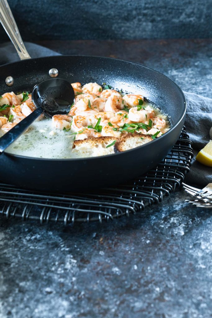Black pan filled with lemon garlic butter shrimp 