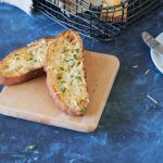 Two slices of toasted bread topped with butter, garlic and cheese