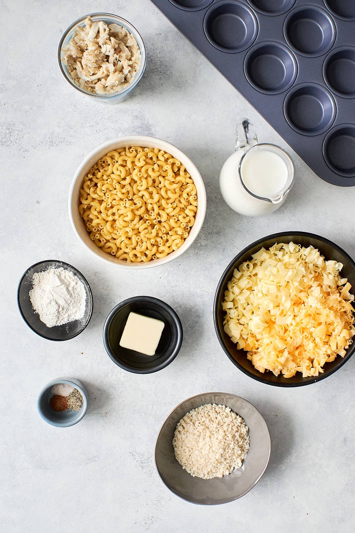 Small bowls of ingredients for mac and cheese bites
