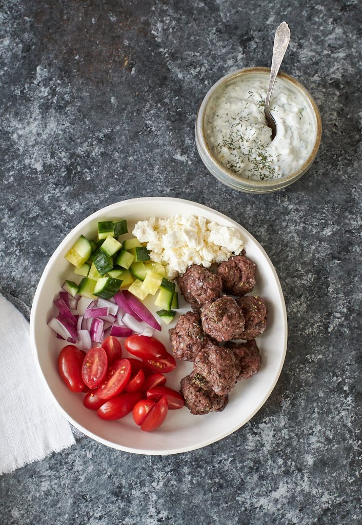Plate with lamb meatballs, grape tomatoes, cucumber and feta cheese