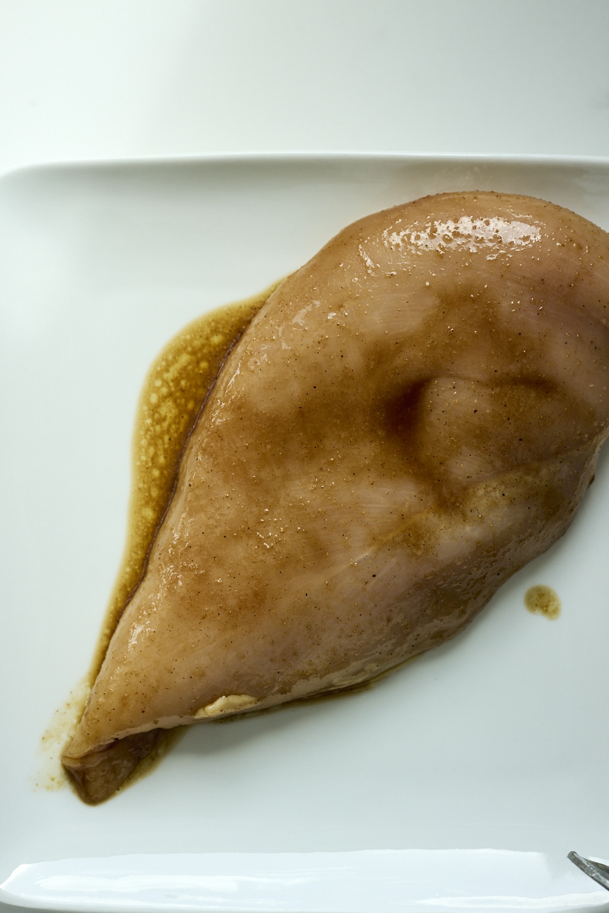 chicken breast on a plate coated with marinade