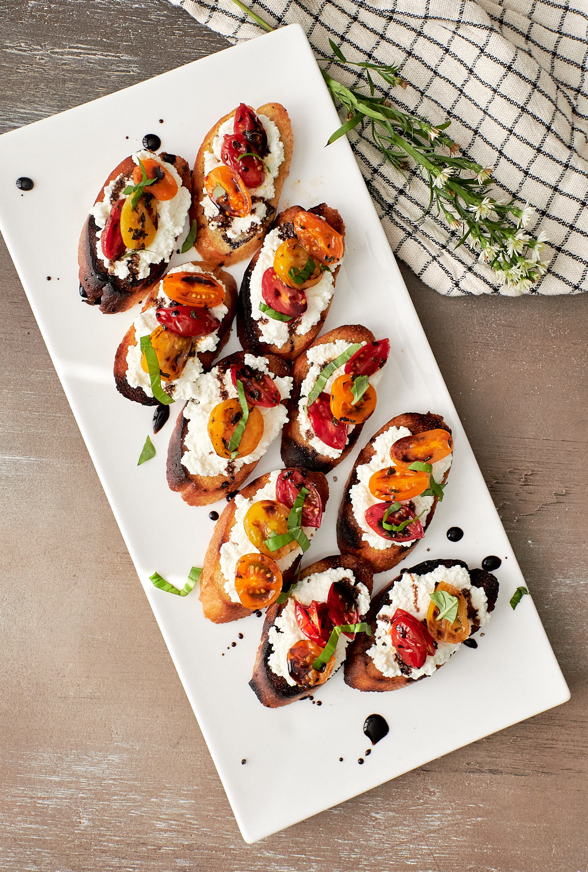 Toasted bread slices topped with ricotta and roasted tomatoes