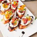 Overhead shot of roasted tomato crostini on a white tray