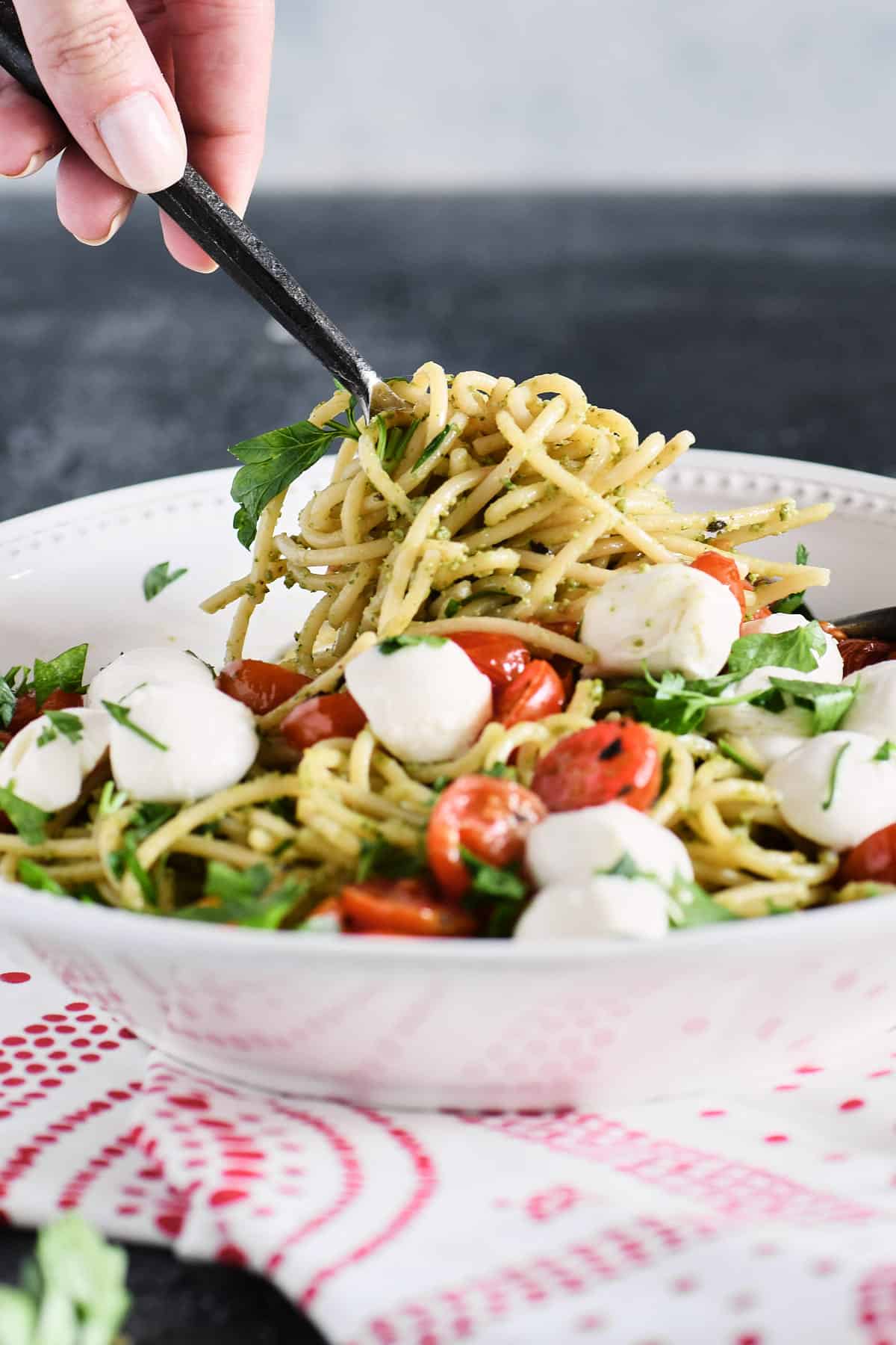 Spaghetti with roasted tomatoes being twirled on a fork