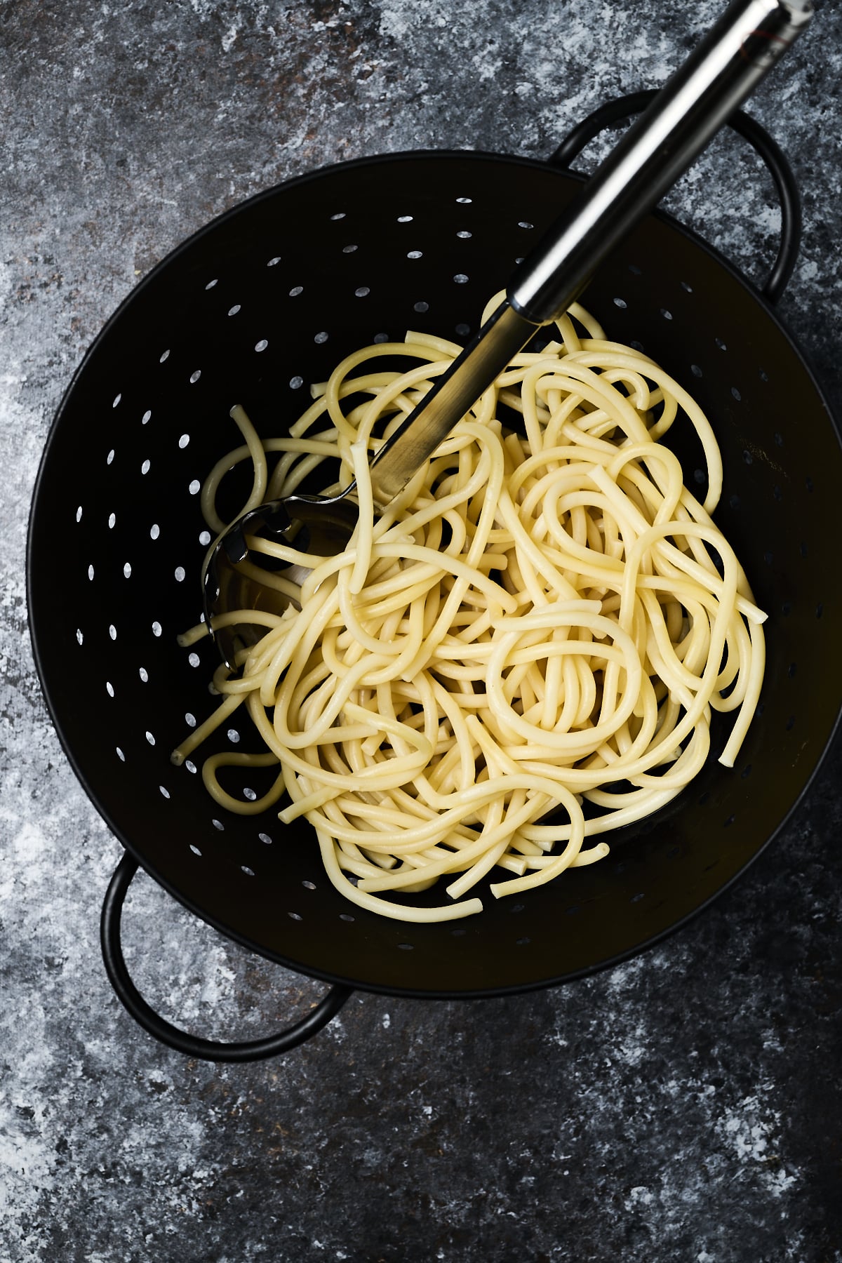Spaghetti in a black pasta drainer