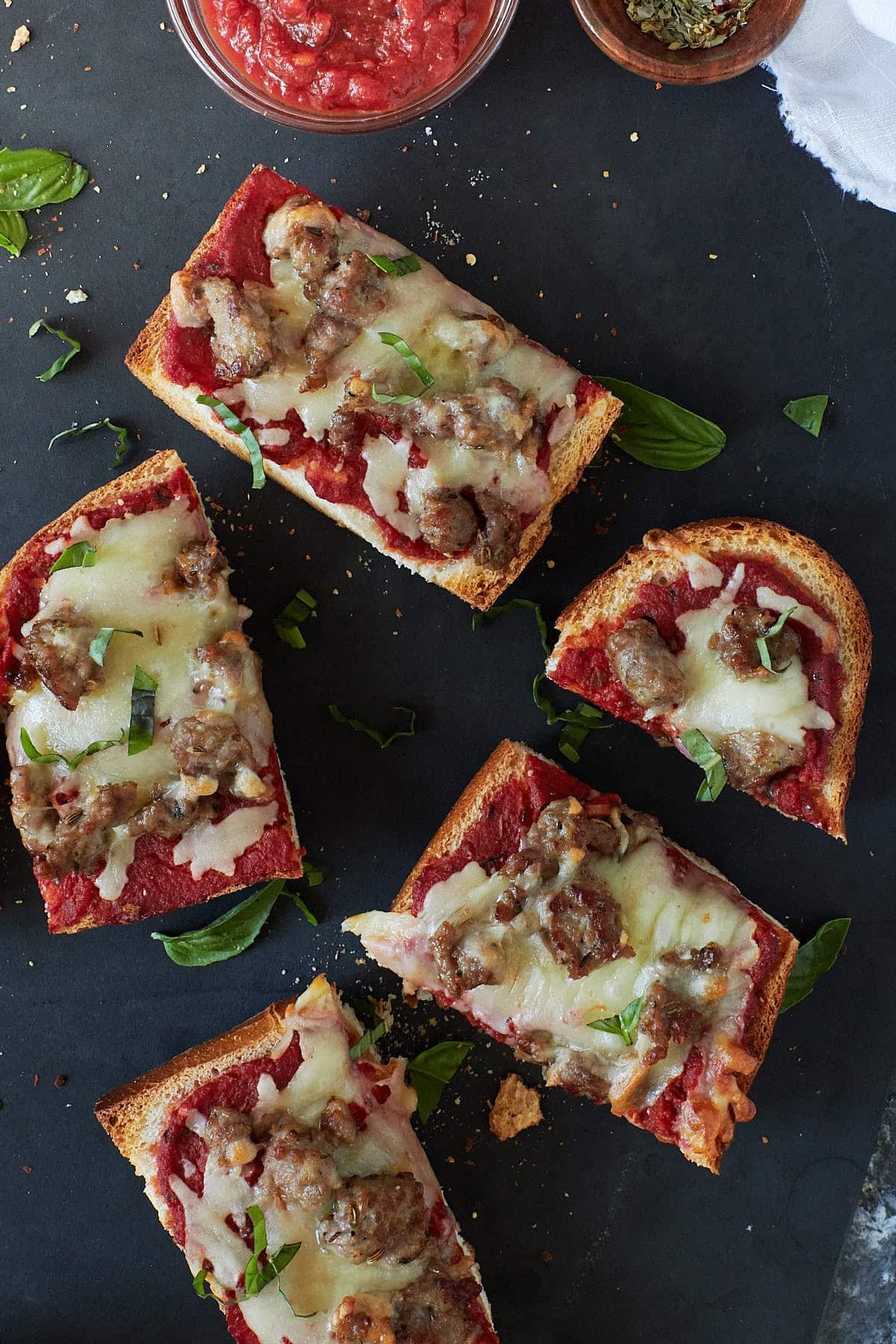 Slices of french bread pizza on a dark slate background