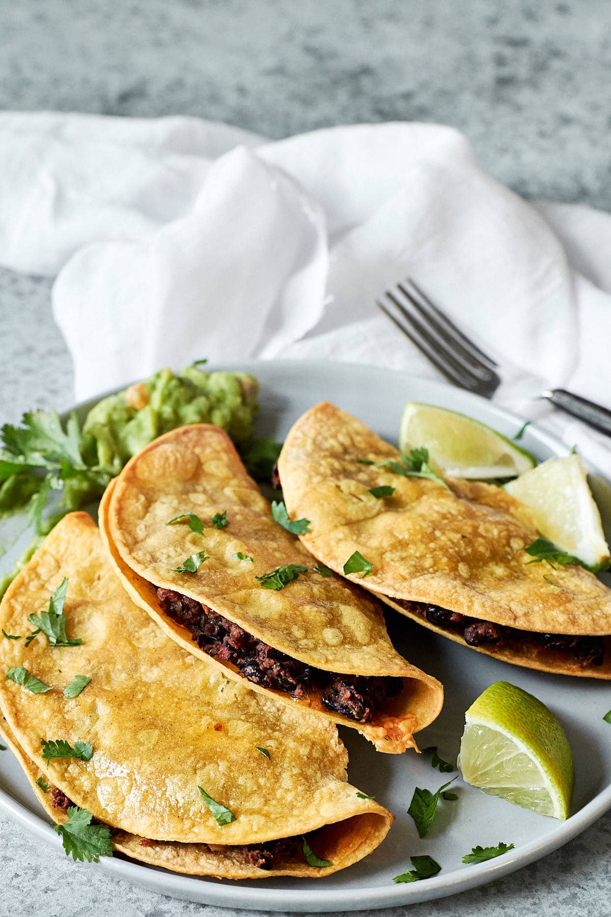 Three crispy corn tortillas stuffed with black bean filling