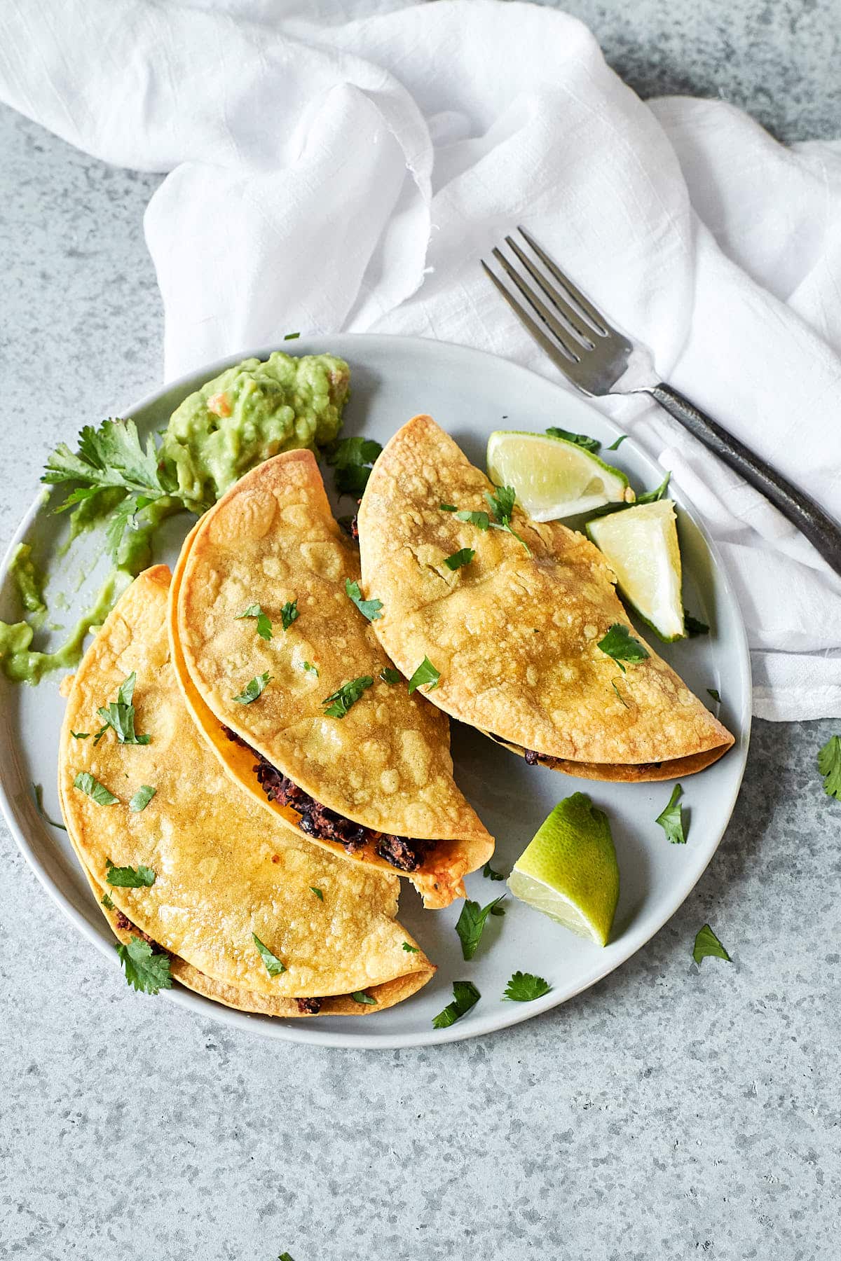 Ovehead shot of crisp baked tortillas stuffed with black bean filling