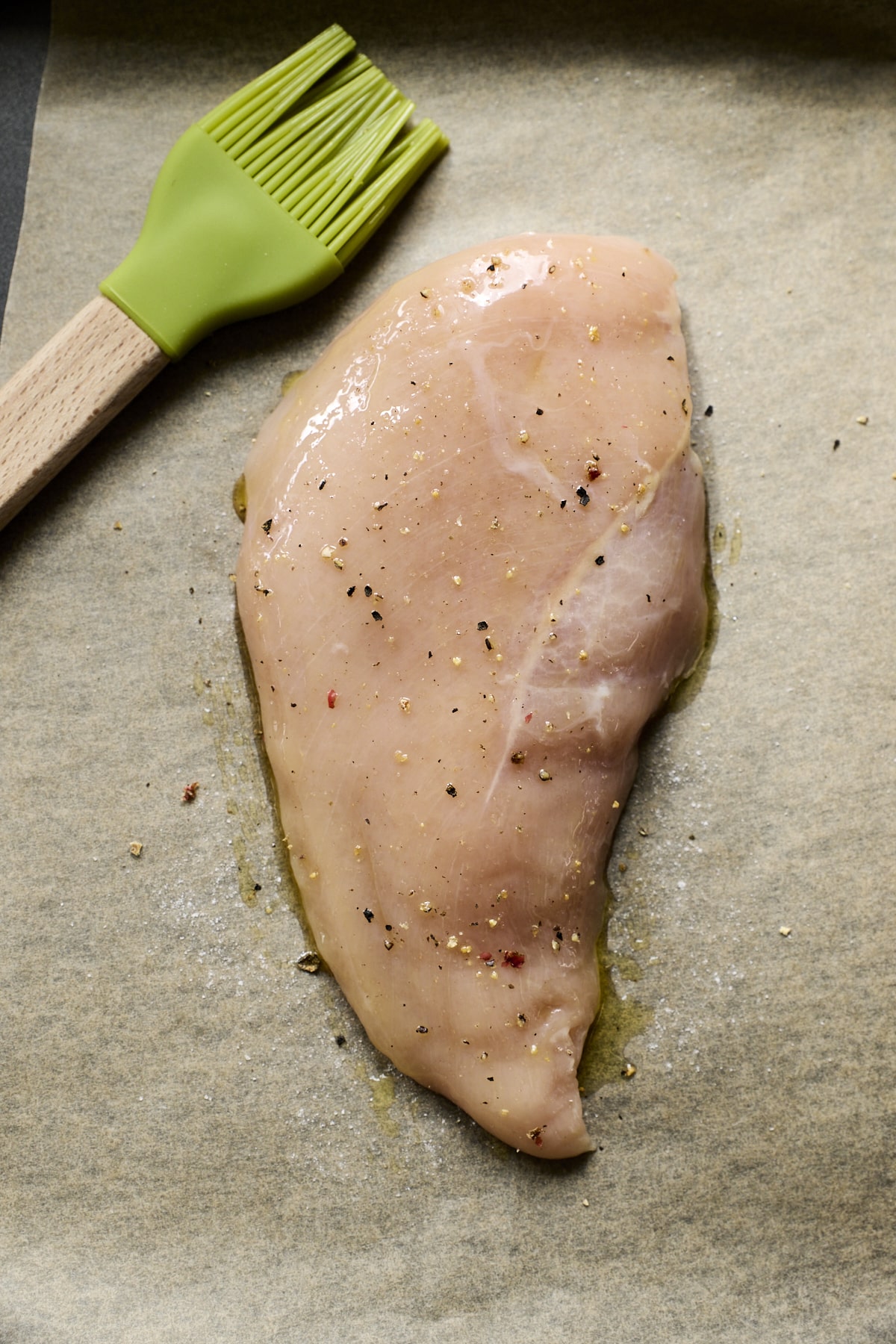 Seasoned chicken breast on parchment paper