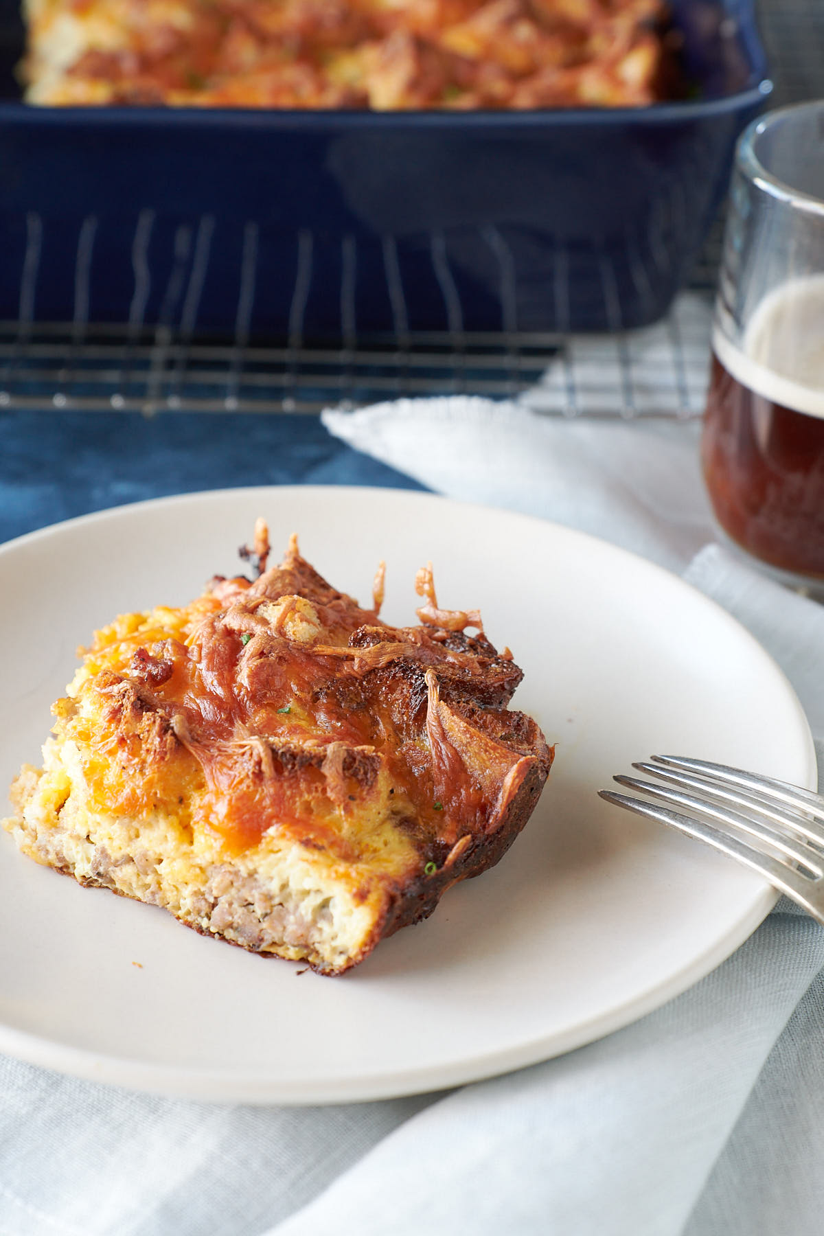 A serving of baked eggs, sausage and cheese on an off-white plate
