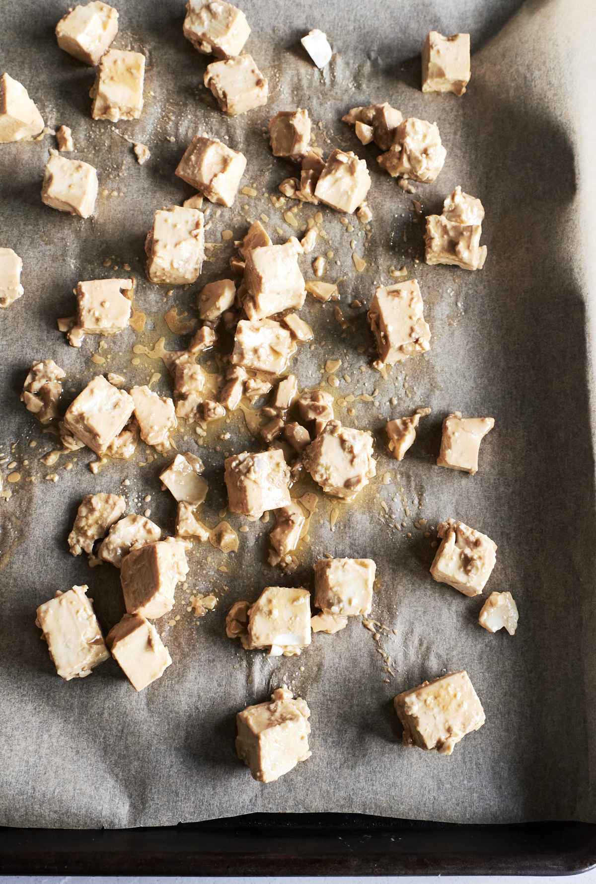 Cubed and seasoned tofu on a baking sheet