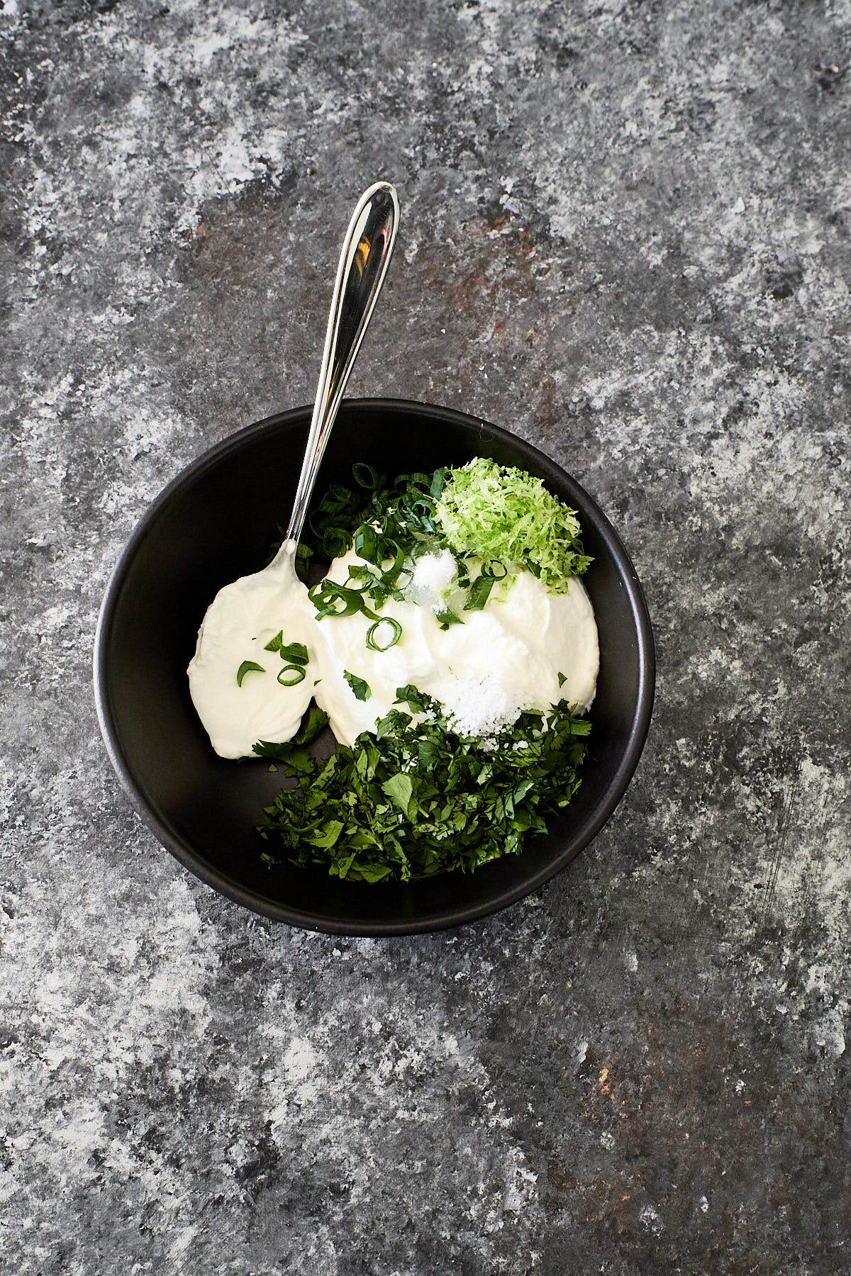 Ingredients for cilantro lime sauce in a black bowl