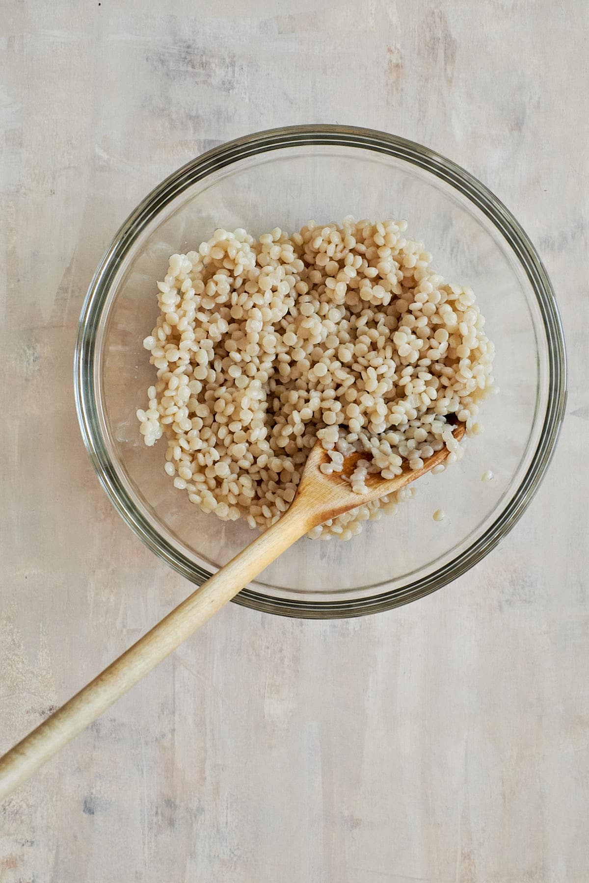 Cooked pearled couscous in a glass bowl
