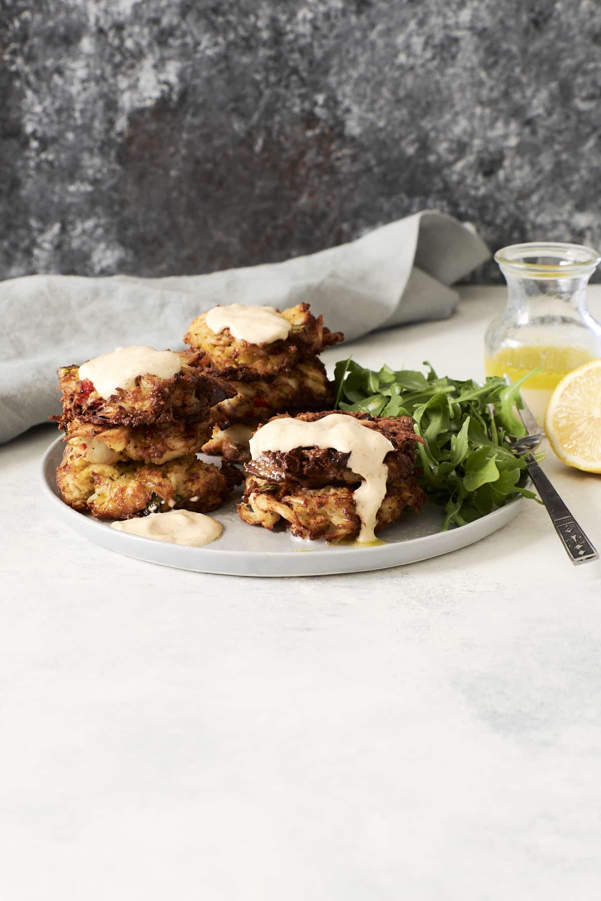Stacks of crab cakes made in the air fryer and topped with spicy aioli