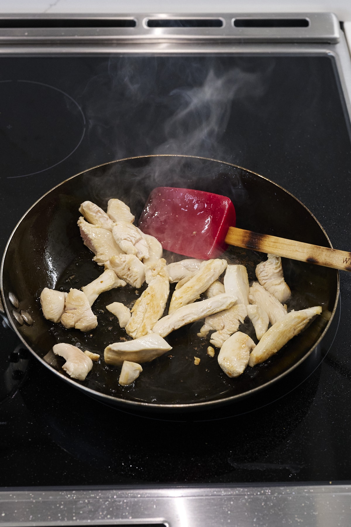 Chicken strips cooking in a wok