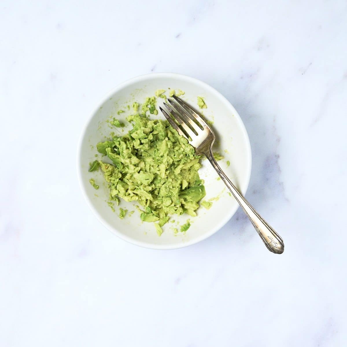 Small bowl with smashed avocados for breakfast quesadillas 