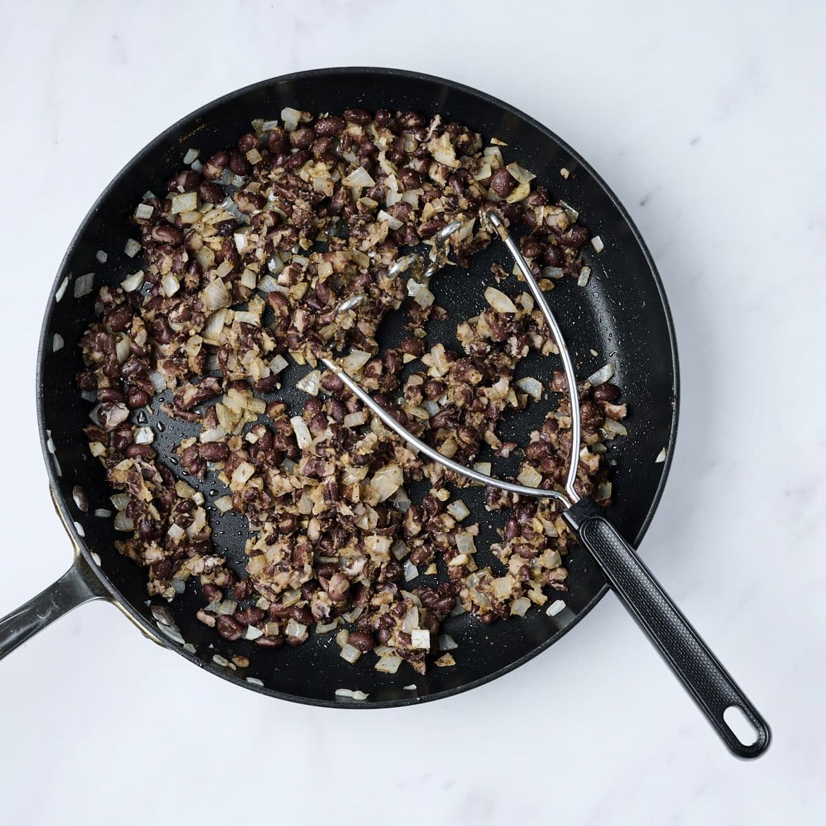 Seasoned black beans cooking in a pan