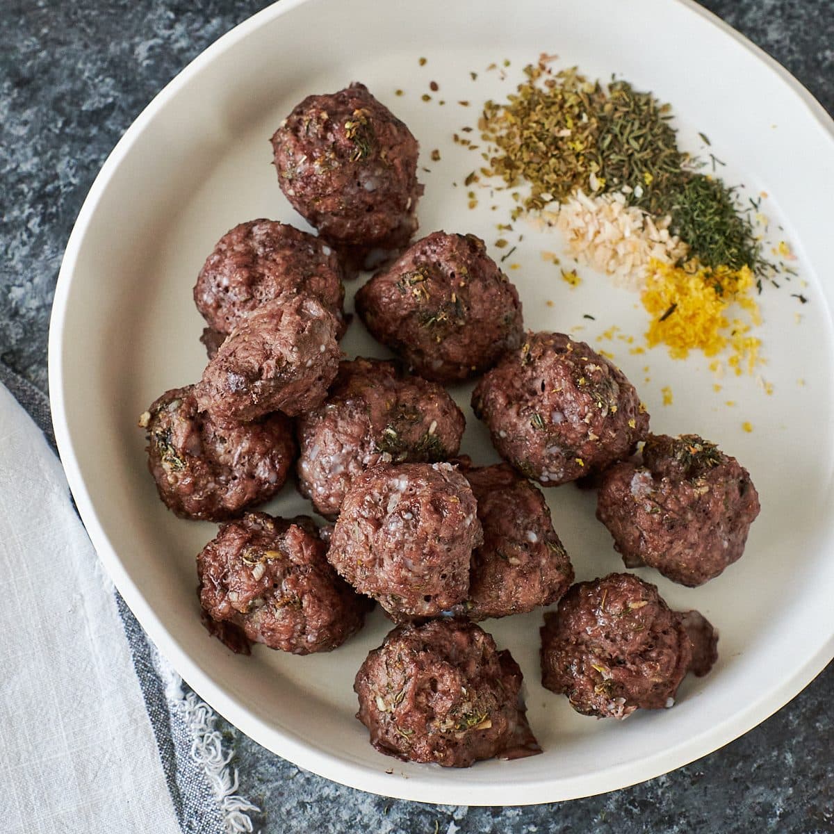Cooked lamb meatballs on a white plate