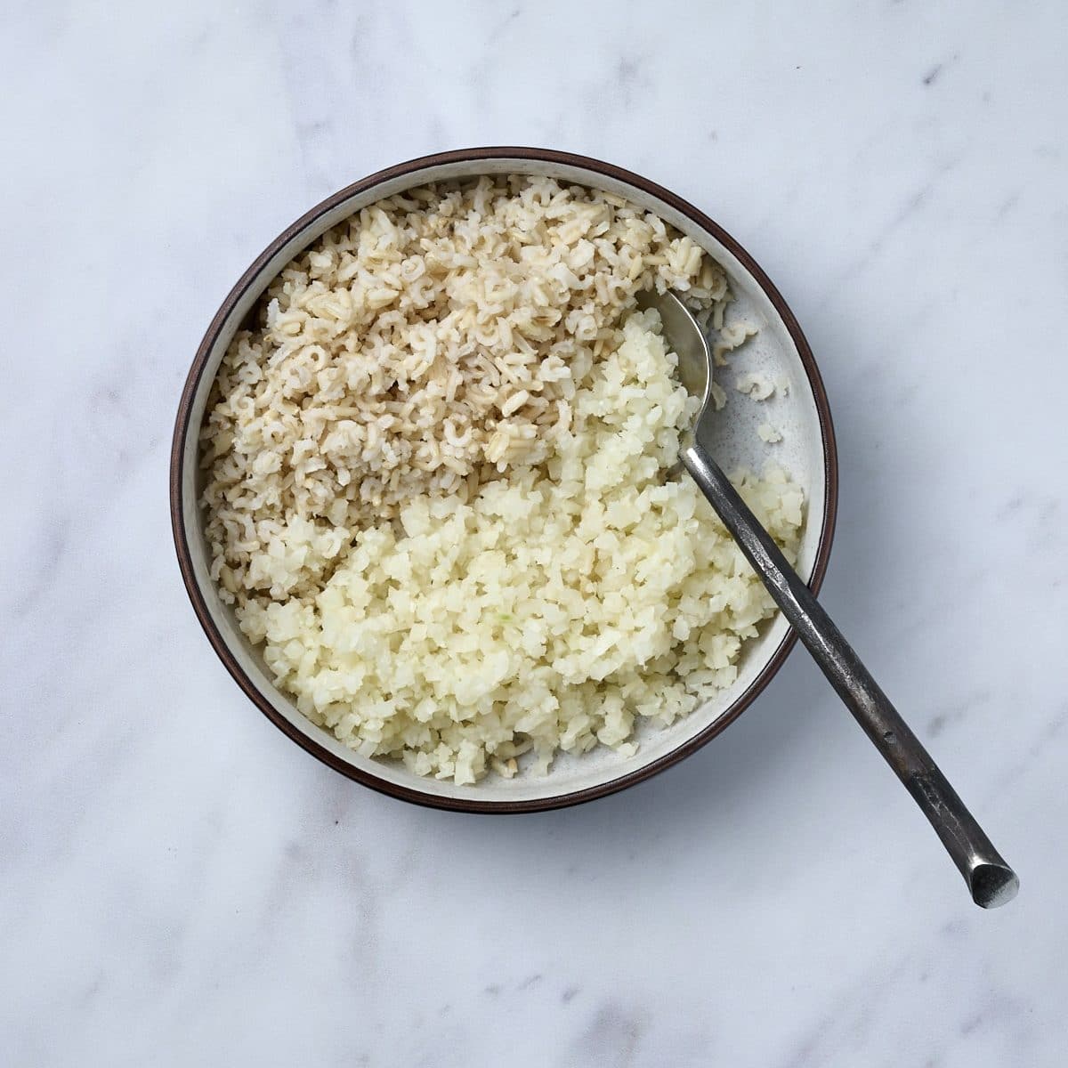 Low bowl filled with a combination of brown and cauliflower rice